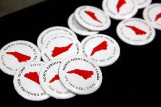 North Carolina campaign buttons sit on a table before the start of a rally with Trump in Fletcher, North Carolina