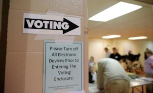 A sign points the way toward the voting booths as voting commences in North Carolina's U.S. presidential primary election at Sharon Presbyterian Church in Charlotte